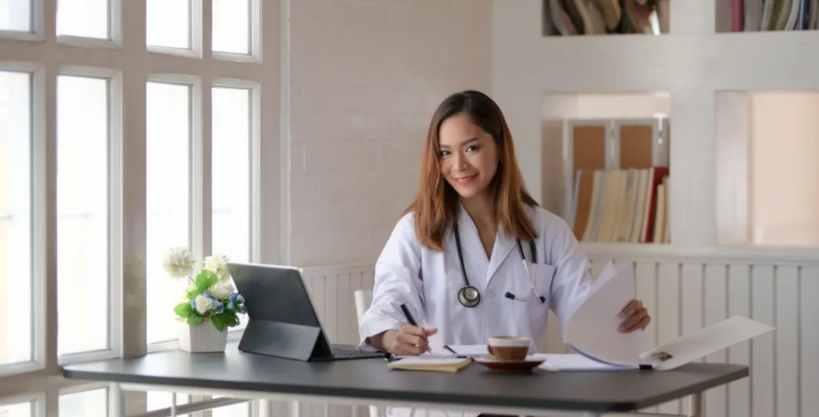 Médica gestora analisando o planejamento tributário para escolha do regime ideal do consultório.